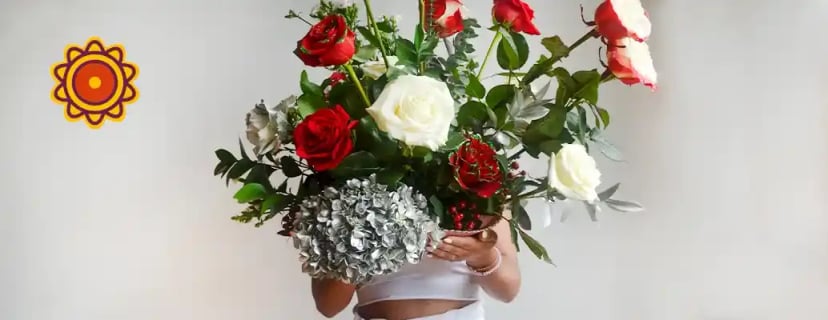 Luxurious bouquet featuring red and white roses, apricot scented rose, light green and rose gold accents, sunset rose dyson airwrap, rose petals.